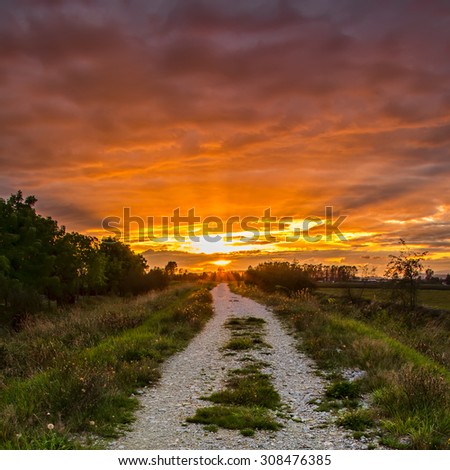 Gravel path with vibrant orange sunset.