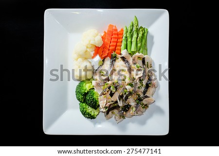 Slice steamed fish with braised leeks topping and spicy sauce in black background