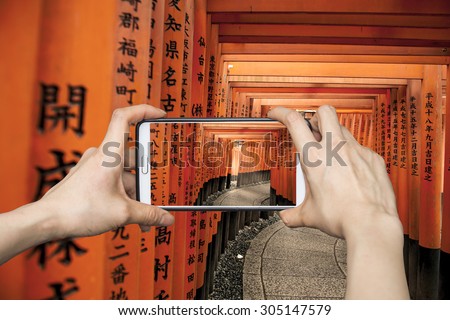 Girl taking pictures on mobile smart phone in Tori gate,Hiroshima,Japan