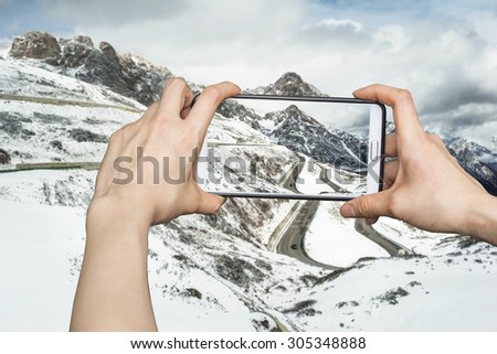 Girl taking pictures on mobile smart phone in snow mountain,China