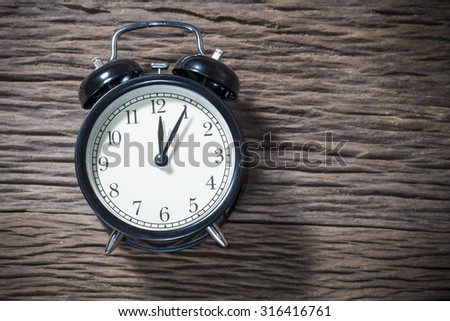 Retro alarm clock on a wood table. Photo in retro color image style