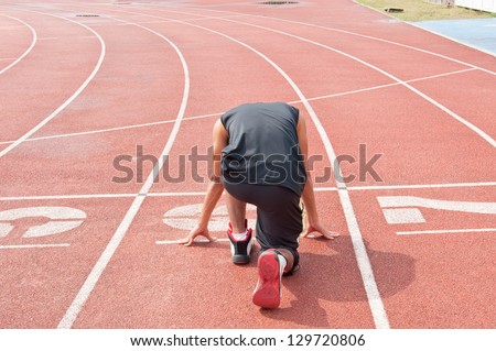 Athletic man on track starting to run