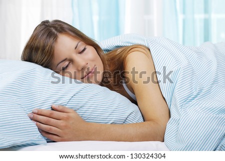 Young woman with her head on a pillow in the bedroom
