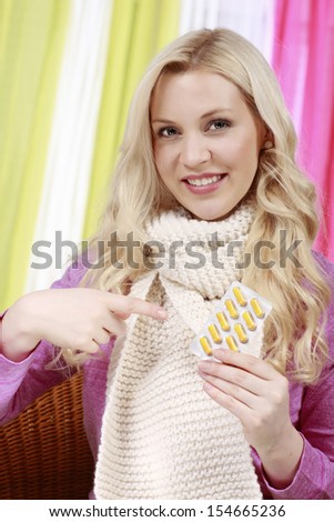 Attractive woman points to a package of tablets
