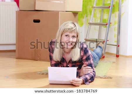 Happy woman with rental contract in front of moving boxes