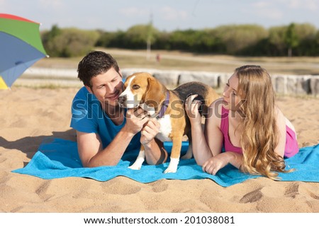Couple with beagle on the beach