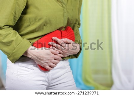 Woman with tummy ache and hot bottle