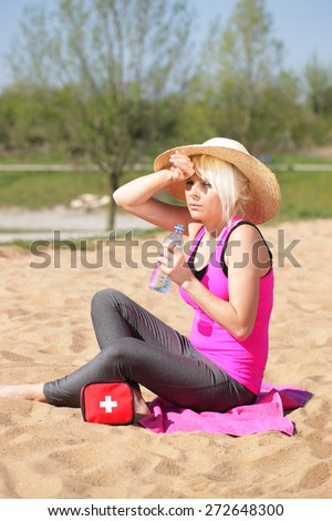 Woman with sun hat and first aid box