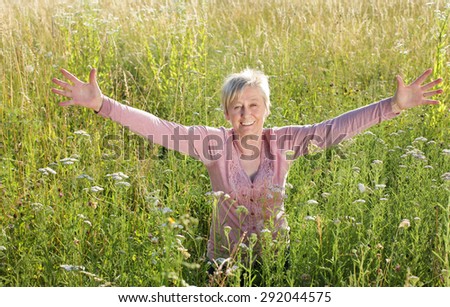 Happy senior woman active in nature in summer