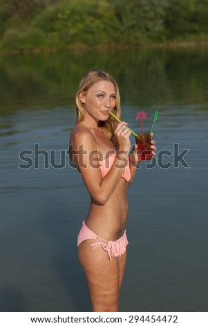 Happy woman with cool drink in the water outdoor