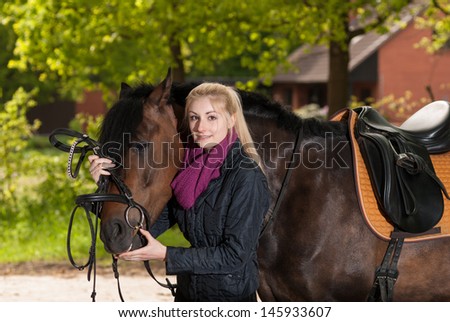 Girl bridles her brown pony (New-Forest-Pony)