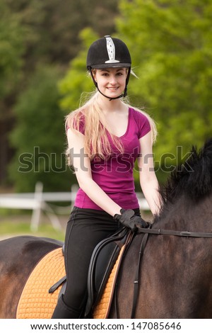 Girl sits on her brown horse (New-Forest-Pony)