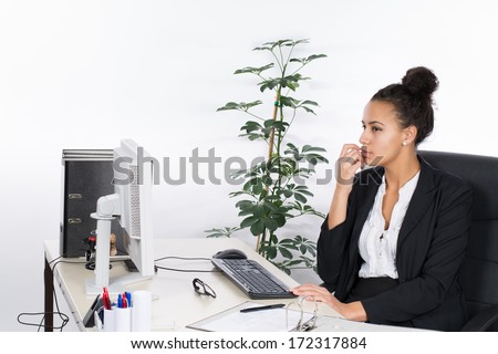 Young, beautiful office worker sits thoughtfully at the desk in the office