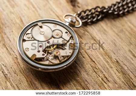 pocket watch mechanism on wood background