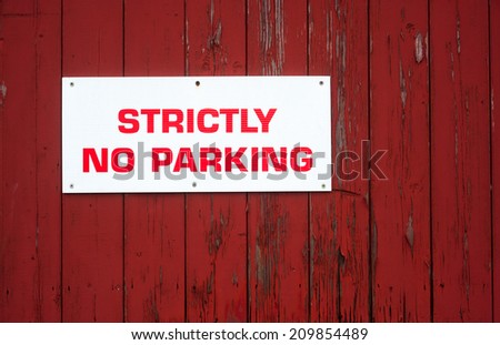 strictly no parking sign on red wood background texture