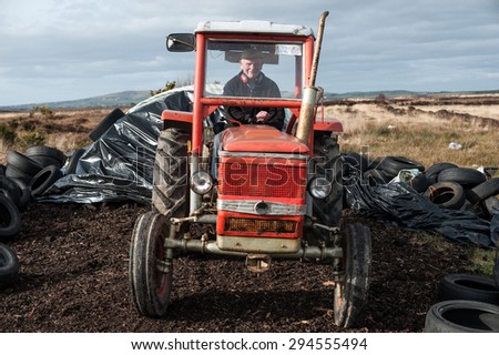 County Kerry, Ireland - 3rd march 2015: Farmer collecting turf in a in a peat bog marsh in rural north Kerry, Ireland