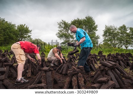 County Kerry, Ireland - June 14, 2014: Workers cultivating a peak bog field outside the town of Listowel in County Kerry