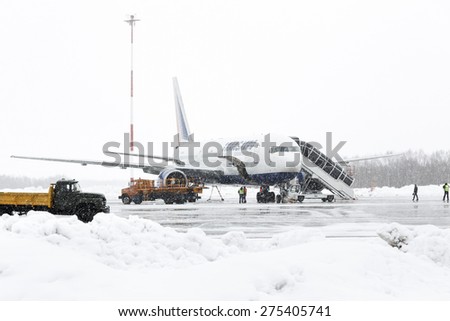 KAMCHATKA, RUSSIA - MARCH 19, 2015: Service and technical support airfield maintenance airplane Boeing-767 Transaero Airlines at airport of Petropavlovsk-Kamchatsky at time of bad weather (snowfall).