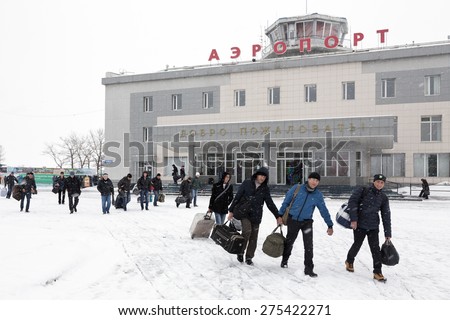 PETROPAVLOVSK-KAMCHATSKY, KAMCHATKA, RUSSIA - MARCH 19, 2015: Winter view of the airport terminal Petropavlovsk-Kamchatsky (Yelizovo airport) and the station square with the passengers with baggage.