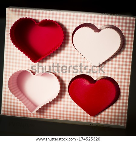 Four heart shaped molds for cupcakes in Valentine\'s Day on a vintage style.