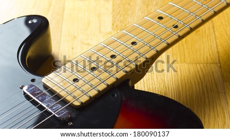 A left handed electric guitar close up shot on a wooden background.