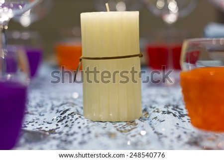 White candle home decoration on a served holiday table on a restaurant.