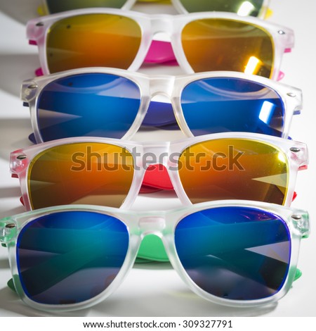 Many different colorful sunglasses in a row isolated on a white background