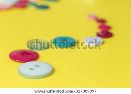Curved line sewing buttons on a yellow background