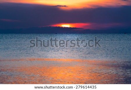 Glittering sea and calmly wave at sunrise, a little tidal. Sun just come up. Dazzling reflection from sunlight on sea surface.