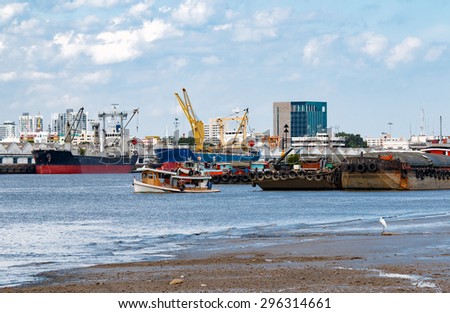 Cargo Ship and Tugboat at Estuary with Containers.The Importance of business logistics.