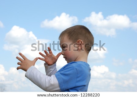 Little boy over cloudy blue sky showing long nose