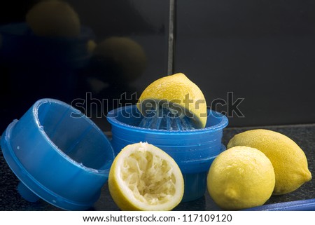 Lemon Squeeze/ Fresh lemons and a blue plastic hand juicer