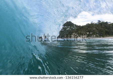 breaking wave/ a perfect surf wave pitches and tubes, shot using a water-housing