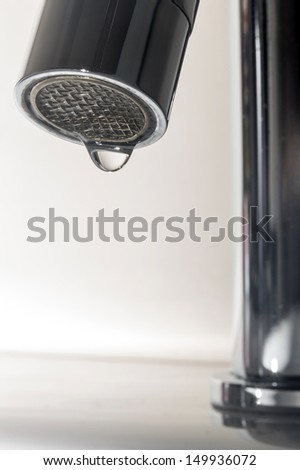 Leaky Tap/ a chrome bathroom tap with a faulty washer causing a leak or drip