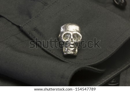 Skull Cuff Link/ A chrome skull cuff link on a black dress shirt