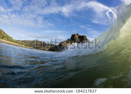 Piha Waves/ a wave breaks in front of Piha Beach\'s iconic Lion Rock