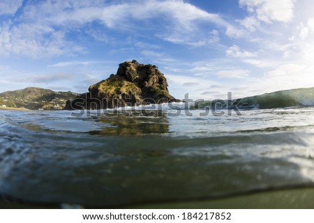 Piha Waves/ a wave breaks in front of Piha Beach's iconic Lion Rock