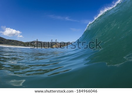 Wave Peaking/ a perfectly glassy wave peaks and is about to pitch at North Piha Beach, New Zealand