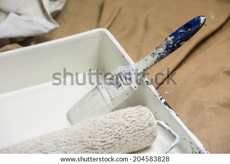 paint tray/ a paint tray, roller and paint brush with white paint