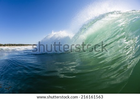 Backlit Wave/ a perfect wave breaks with the sun flaring through it\'s pitching lip
