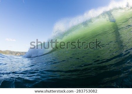Wave Breaking/ an aqua green wave breaking in evening light on the west coast of New Zealand