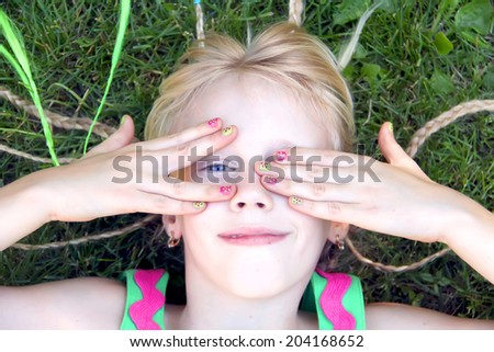 Funny little girl hiding her face with her hands