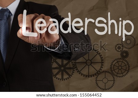 businessman hand writing leadership skill with gear on crumpled recycle background as concept