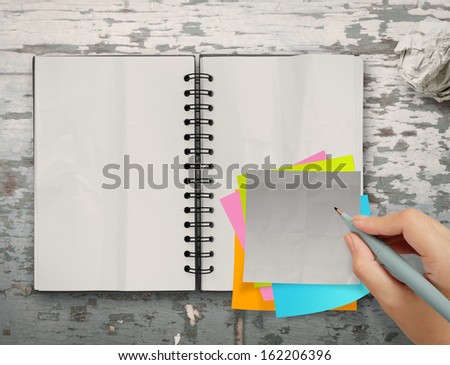 sticky notes with open blank note book on desk top texture