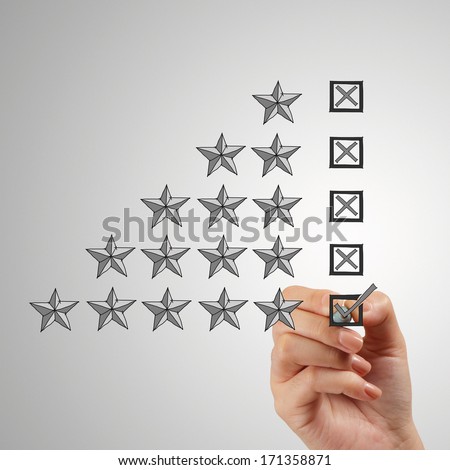 close up of hand putting check mark  on five star rating on screen as concept