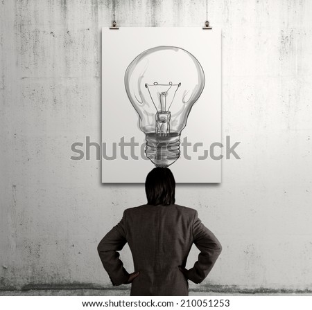 businessman looking at light bulb in art frame on the wall as concept