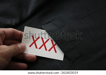 close up of businessman hand picking business card reading XXX from the pocket of gray suit jacket background