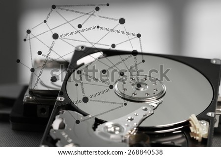 Close up of open computer hard disk drive with social network diagram on desk and notebook