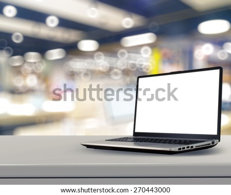 Laptop with blank screen on white desk with blurred background as concept