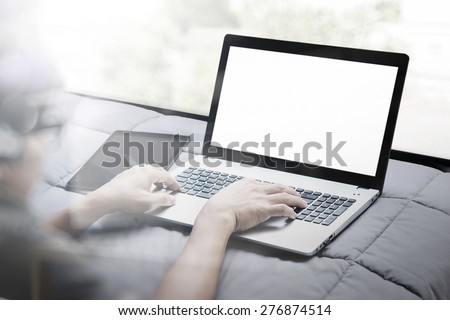 double exposure of young designer working with smart phone and blank screen laptop computer in bed as concept